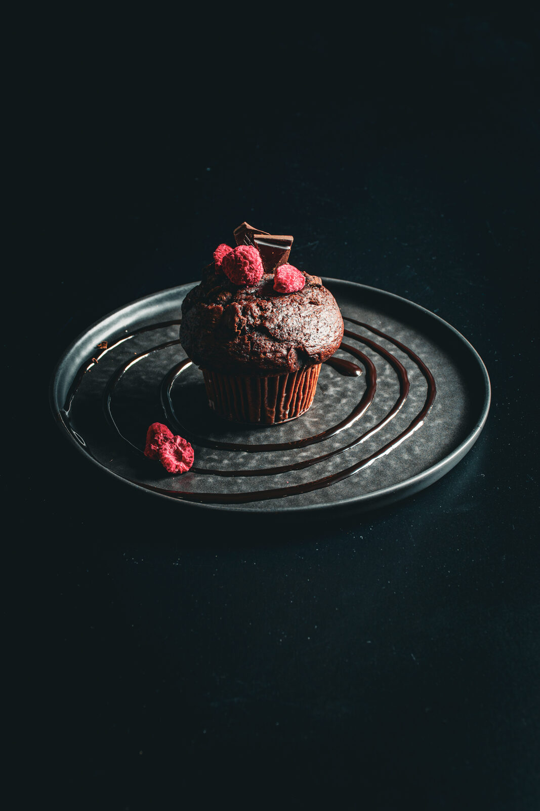 Schokoladenmuffin mit Himbeeren auf Teller